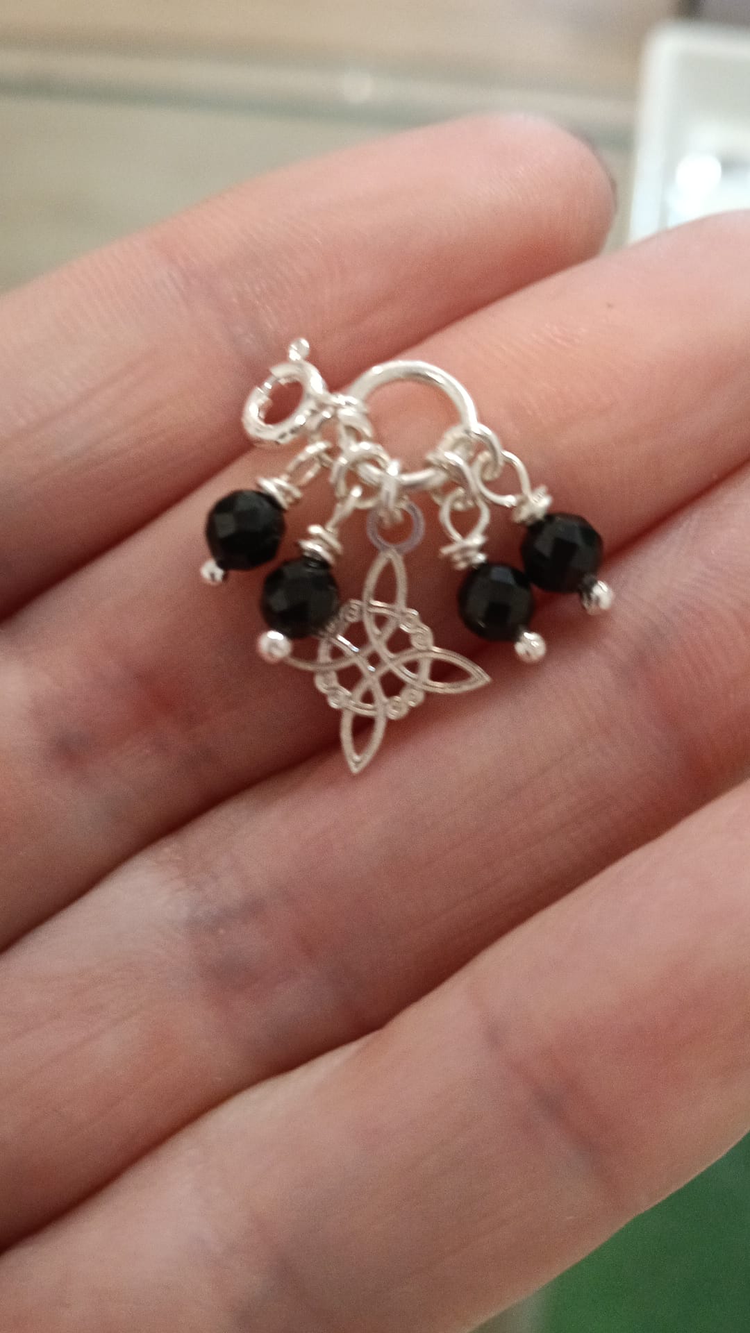 Moña en plata ( nudo de bruja con bolas facetadas de turmanila negra)